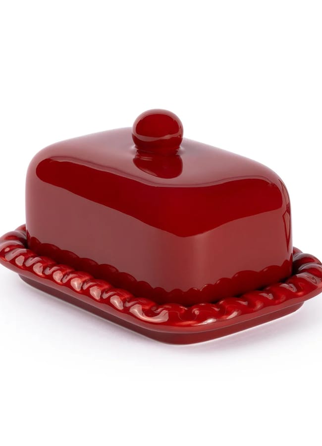 A shiny, deep red ceramic butter dish—perfect for fans of the Unexpected Red Theory in interior design—features a round knob and wavy edge, set against a plain white background. A striking accent for any 2026 table setting.