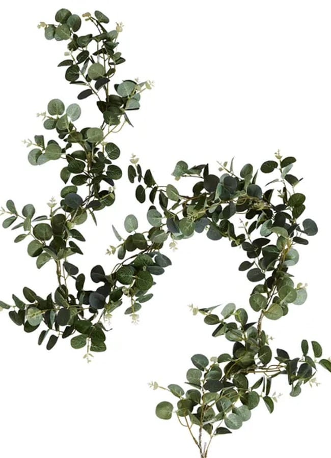 A long, leafy garland of artificial eucalyptus branches with round green leaves and small white flowers, perfect for adding a fresh touch to your Christmas tablescape, arranged in a loose, flowing shape on a white background.