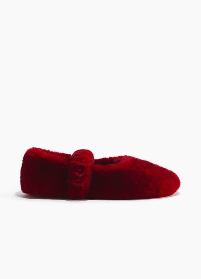 A fuzzy, deep red slipper with a rounded toe and a matching red strap across the top, shown in side profile on a white background—perfect for relaxing after setting your Christmas tablescape.