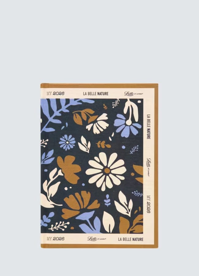 A floral-patterned notebook with blue, white, and brown flowers and leaves on a dark background. Perfect as one of your 2026 diaries, its beige border features the text MY 2023, LA BELLE NATURE, and L’édition limitée.