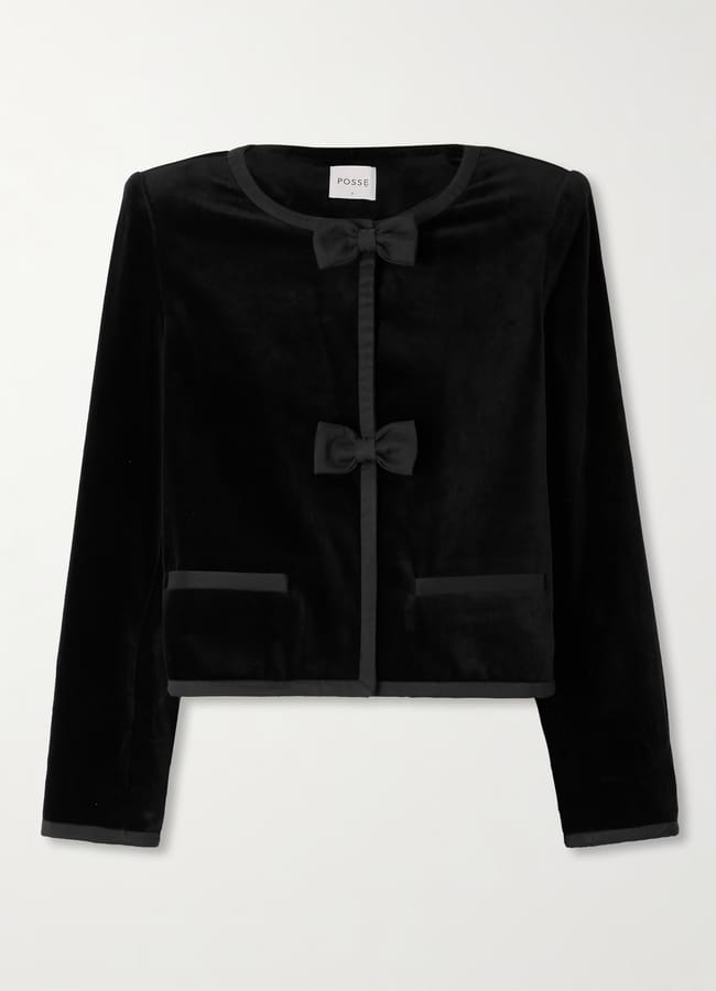 A black, long-sleeve velvet party wear jacket with a round neckline, two decorative bows on the front, and two front pockets, displayed against a white background.