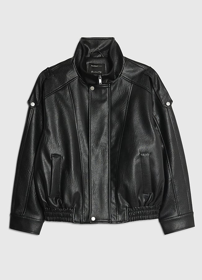 A black faux leather jacket with a high collar, press studs, zip-up front, and two front pockets pairs perfectly with men's brown trousers. Displayed on a plain light grey background.