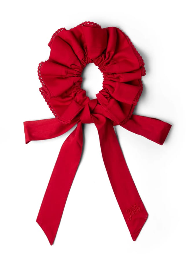 A large, ruffled red scrunchie with lace trim and two long ribbon tails—one embroidered with initials—makes a charming addition to your red accessories collection, displayed elegantly on a white background.