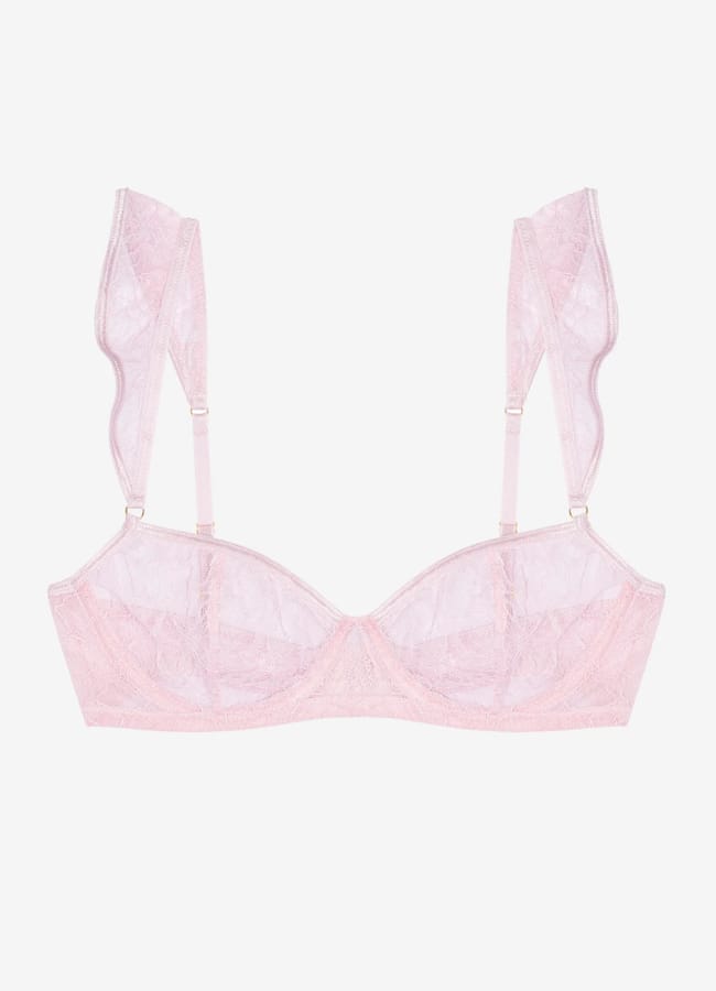 A delicate pastel pink lace lingerie set features sheer cups, underwired support, and wide decorative lace straps, displayed on a plain white background.