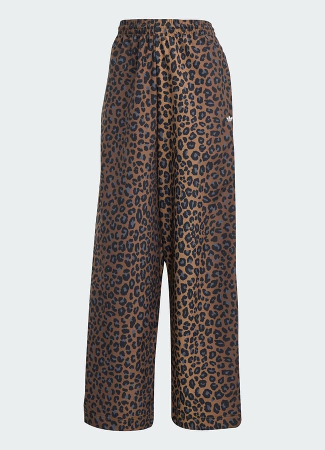 Wide-leg track trousers with an elasticated waistband, showcasing an all-over brown and black leopard print pattern, displayed against a plain light background.