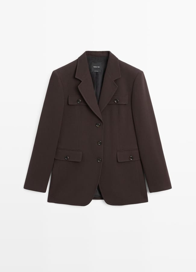 A dark brown tailored blazer with a notched lapel, four black buttons, and multiple flap pockets—an essential pick for any Fashion Editor in search of the Best Blazers, presented against a plain white background.