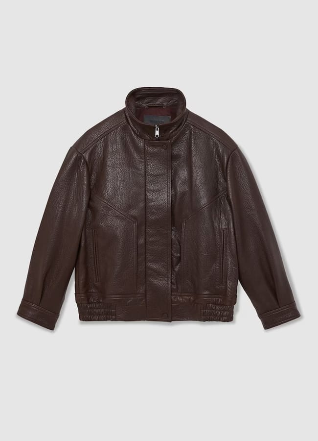 Dark brown leather jacket with a stand-up collar, front zip and press-stud fastenings, two front pockets, and elasticated detailing at the waist and cuffs—perfectly styled with track bottoms—displayed on a plain light grey background.