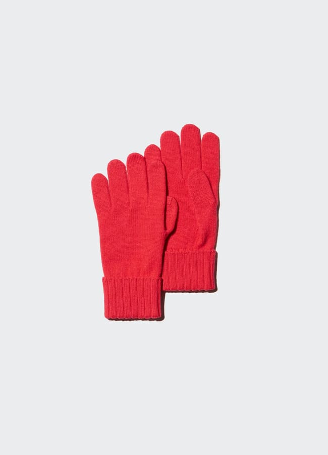 A pair of bright red knitted gloves with ribbed cuffs, classic red accessories, placed side by side on a light grey background.
