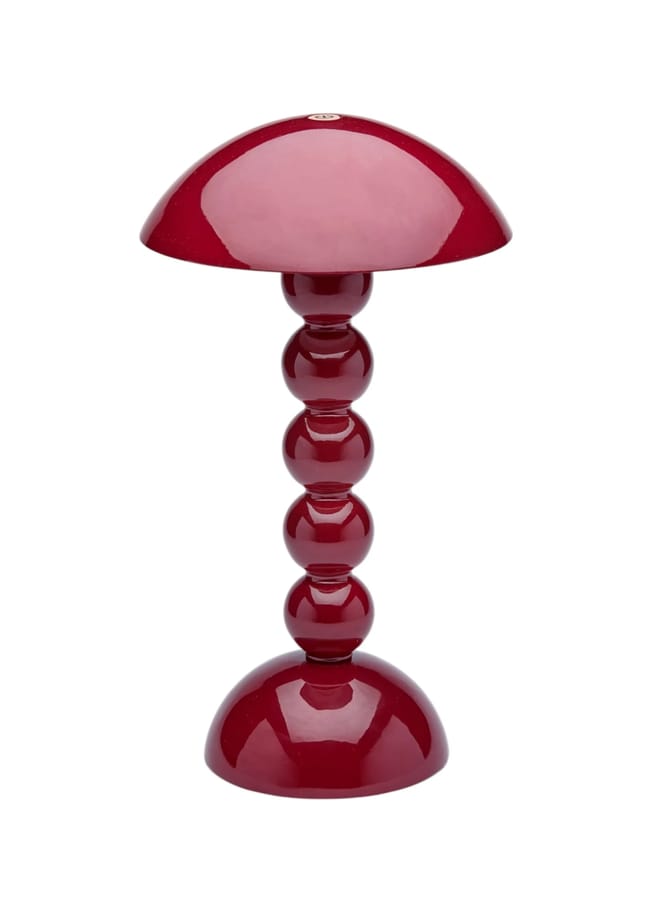 A modern table lamp with a glossy red finish, perfect for red and pink interiors, featuring a dome-shaped shade and a base made of stacked spherical segments.