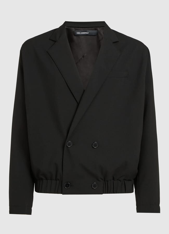 A black double-breasted blazer with four buttons, a notched lapel, long sleeves, and an elasticated waistband—perfect for Casual Date Night Looks. The blazer is displayed against a plain light grey background.