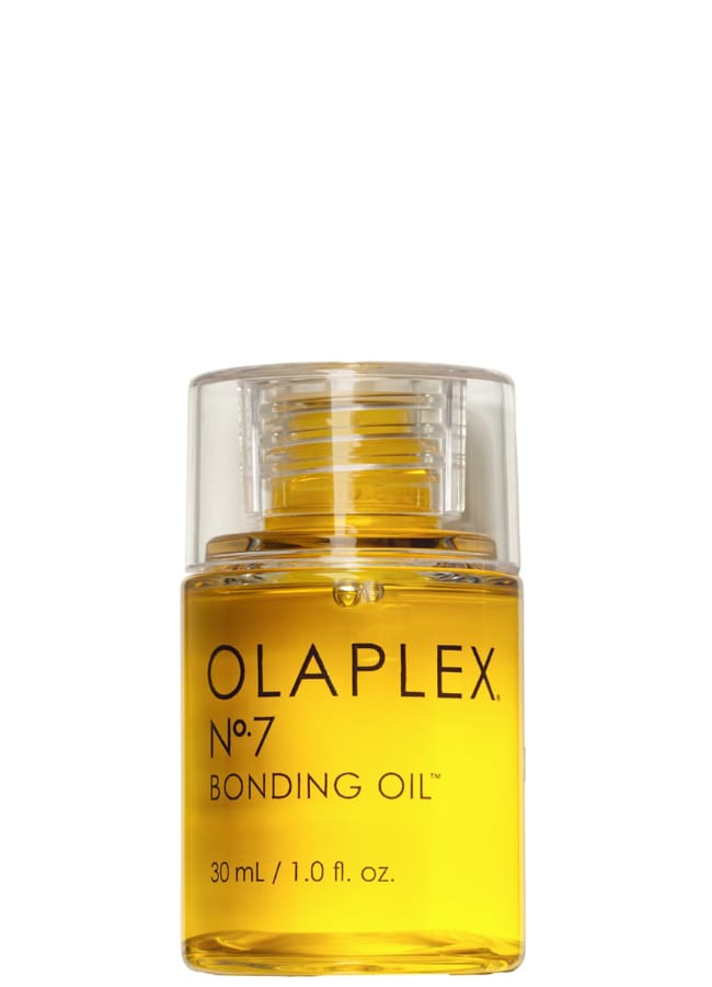 A clear bottle of Olaplex No. 7 Bonding Oil with a transparent cap, filled with yellow oil—perfect for achieving shine and strength, whether you’re rocking sleek strands or a Pamela Anderson mullet. The label shows the product name and size, 30 ml (1.0 fl oz), against a white background.