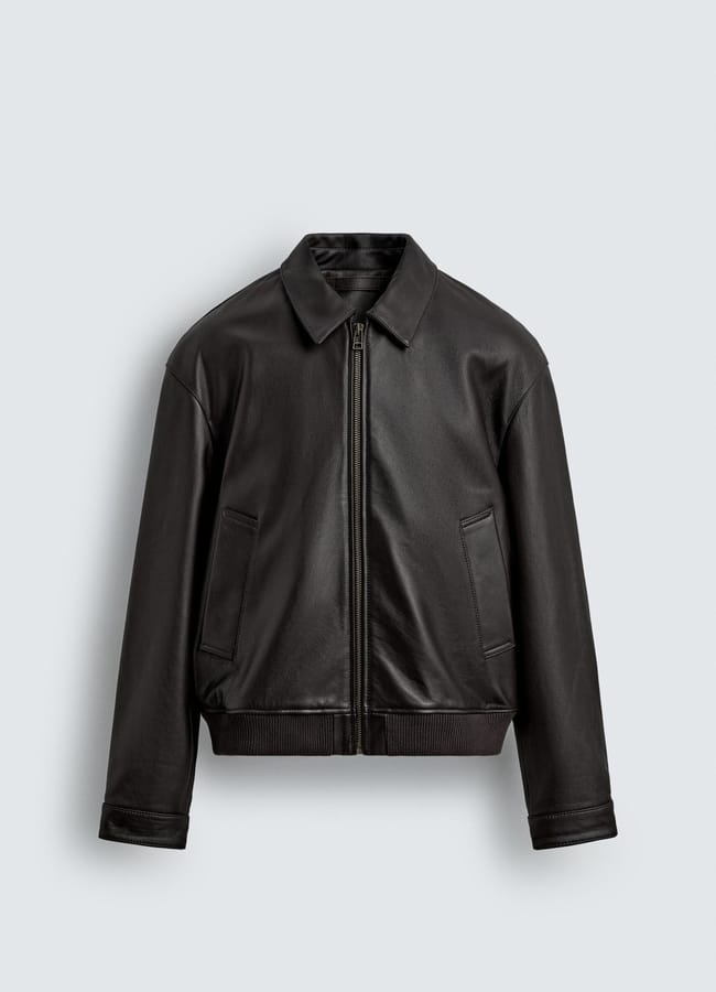 A black leather jacket with a front zip, two angled front pockets, a pointed collar, and ribbed cuffs and hem—perfect for Casual Date Night Looks—displayed against a plain light grey background.