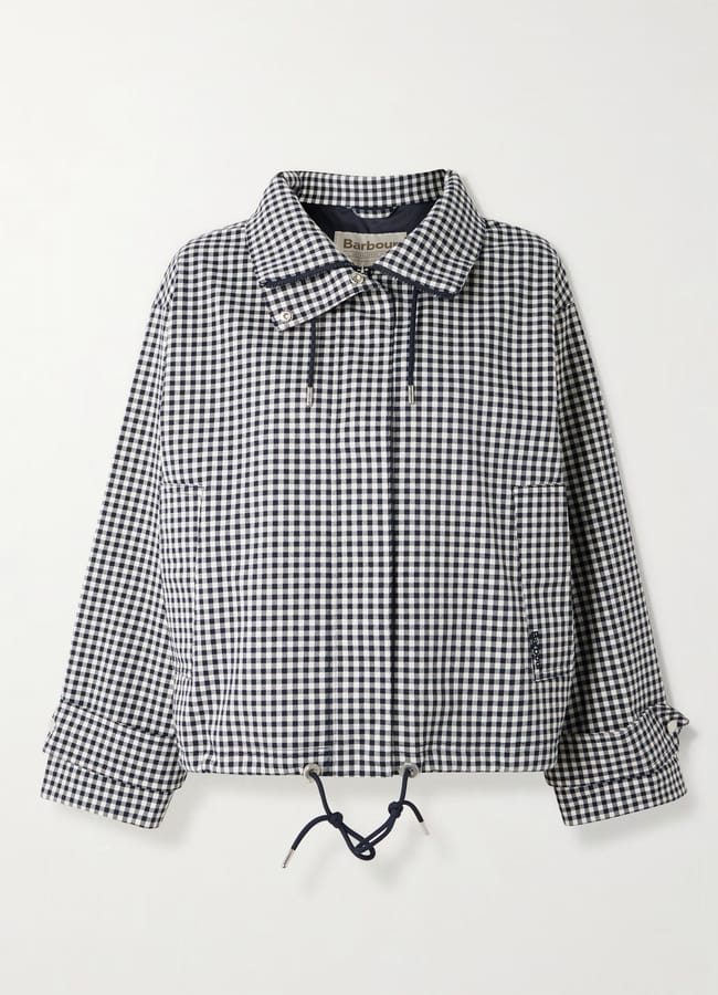 A black and white gingham-checked jacket with a collar, front zip, side pockets, adjustable drawstring at the hem, and buttoned cuffs—this piece offers the classic charm of stylish waterproof jackets, displayed on a plain white background.