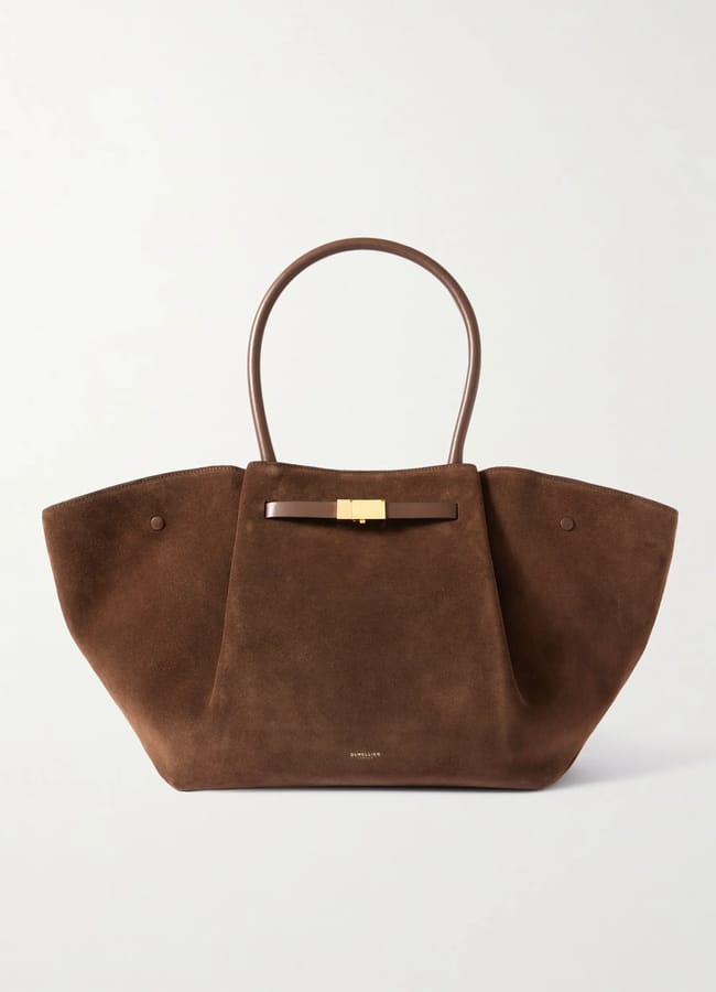A large brown suede tote bag with wide sides, two rounded leather handles, and a gold rectangular clasp on the front. This minimal, elegant design is perfect for those who love stylish large bags.