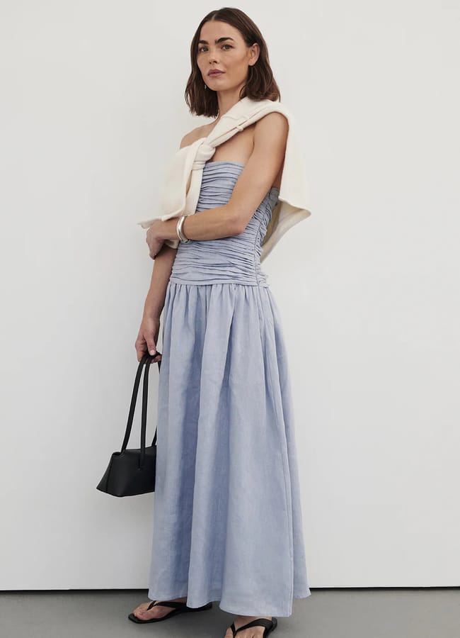 model wearing Dissh Aubriella Dusty Blue Linen Midi Dress with cream jumper over shoulders