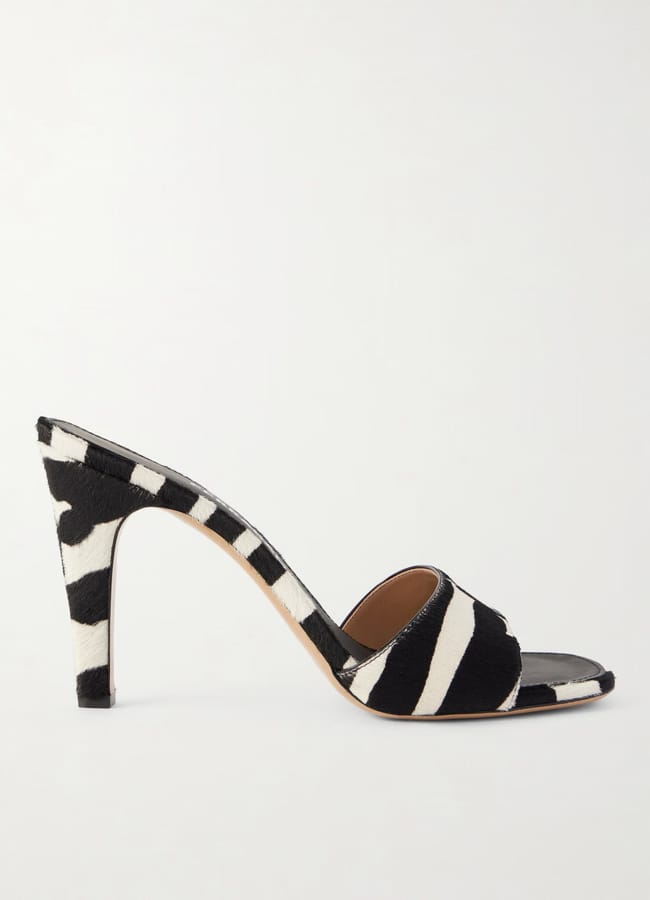 A chic high-heeled mule with a bold zebra print pattern, featuring an open toe and a single wide strap across the front.