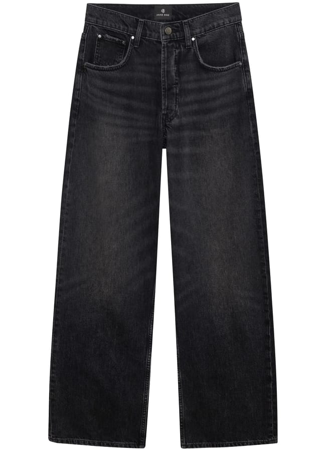 A pair of high-waisted, wide-leg black jeans with a faded wash and subtle sheer accents, featuring front and back pockets, belt loops, and a button and zip fastening.