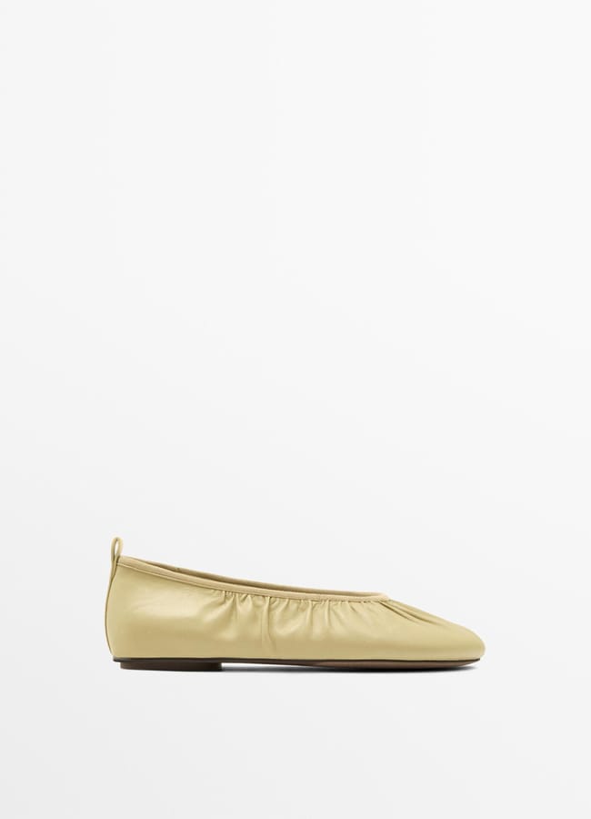 A single light beige ballet flat with a slightly gathered, ruched upper and a small heel, perfect for spring footwear, displayed on a plain white background.