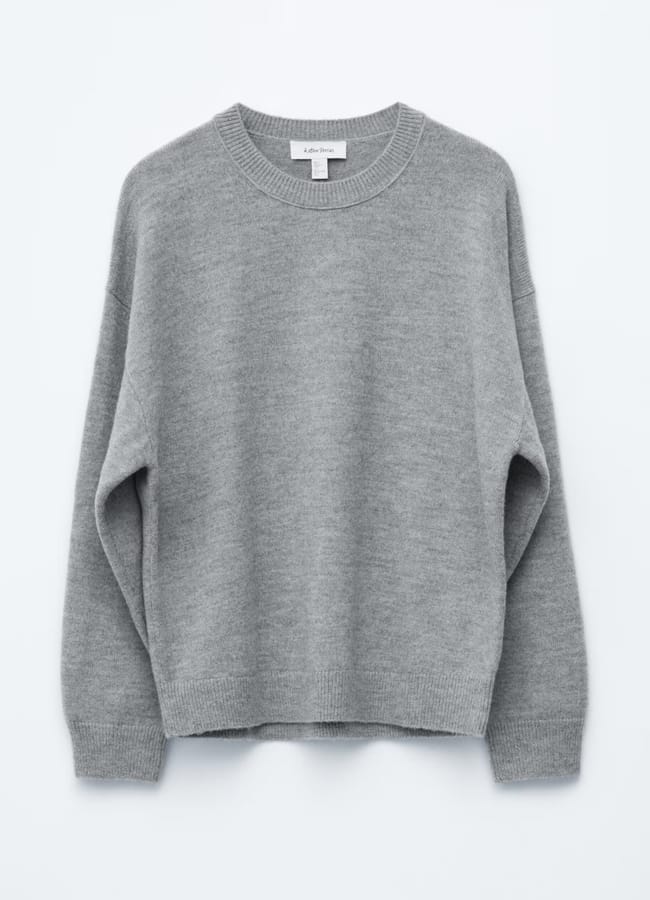 A plain, light grey crewneck jumper with long sleeves and ribbed cuffs, collar, and hem—an essential piece to recreate your favourite wardrobe Insta dupes, displayed against a light background.