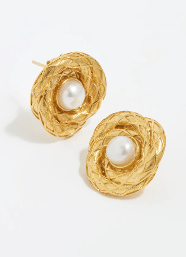 A pair of gold stud earrings with a textured, woven circular design, each featuring a round white pearl at the centre—an elegant addition to refresh your wardrobe or easily recreate trending Insta dupes.