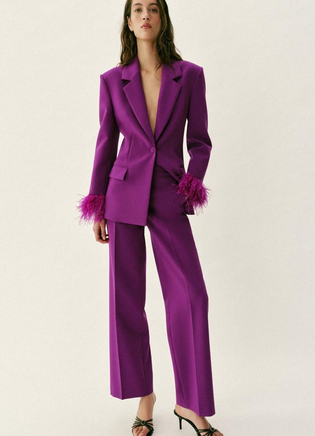 model wearing purple suit with feather cuffs