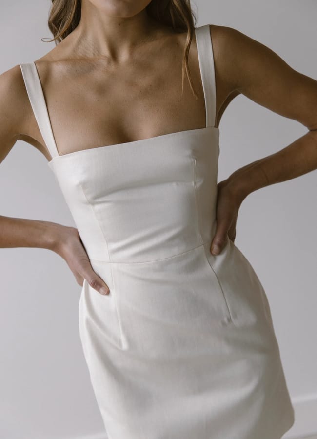close up of model's body wearing white Clover London dahlia dress