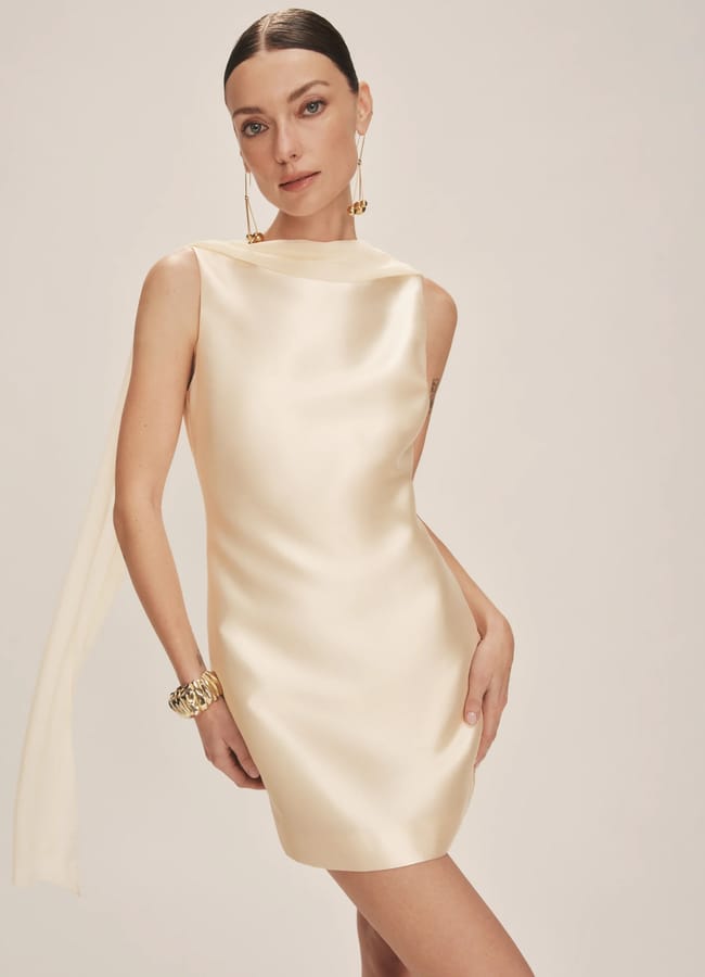 model wearing ecru silk boat neck mini dress with scarf detail