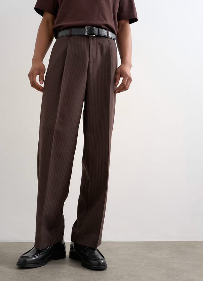 bottom half of male model wearing dark brown tailored trousers