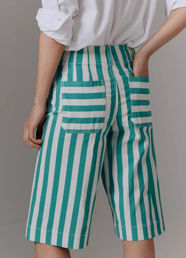 back of model wearing Anthro The Colette Longline Shorts by Maeve in green and white