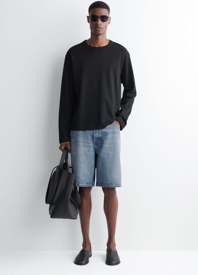 male model wearing black long sleeve tee and COS RIDER RELAXED-FIT DENIM SHORTS