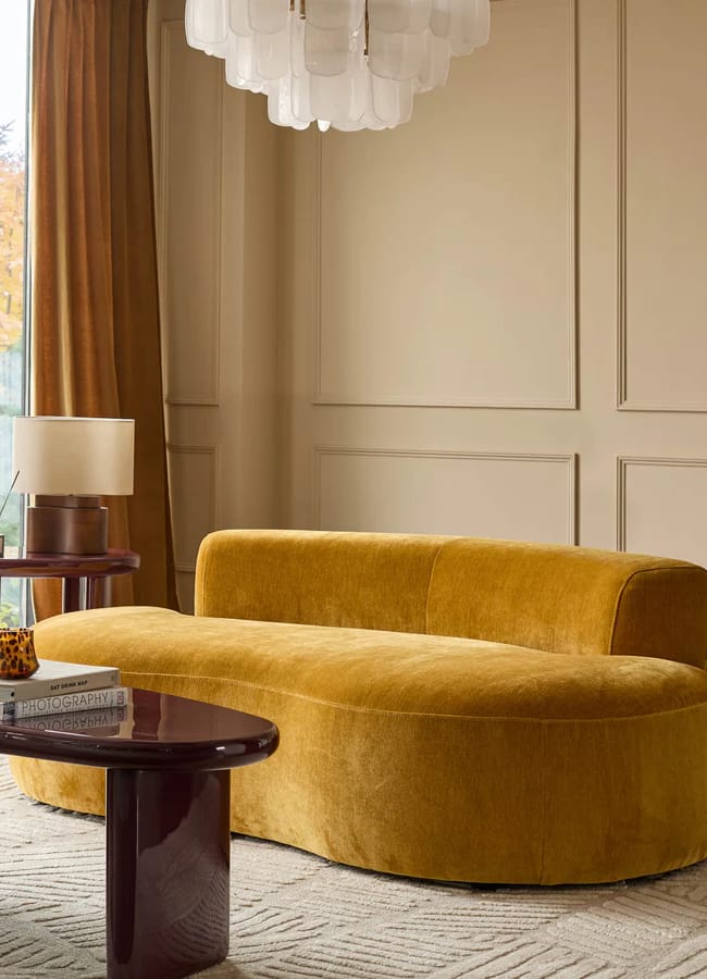 gold yellow sofa in living room with coffee table and pendant light