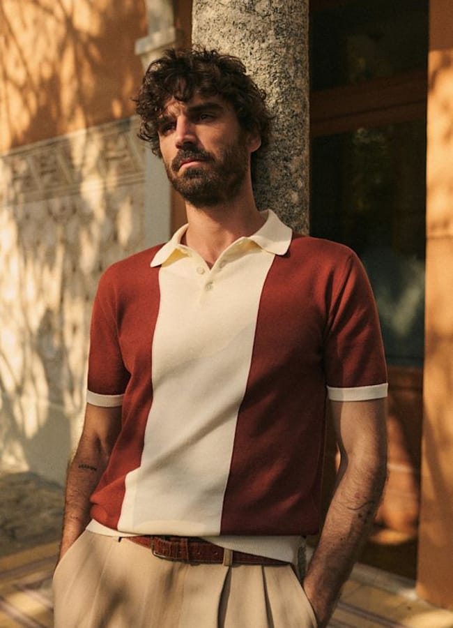 male model leaning against doorway wearing Octobre Editions Tommaso Polo Rust / Ecru