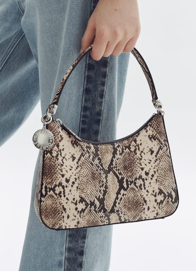 MODEL'S HAND HOLDING Snakeskin-print handbag