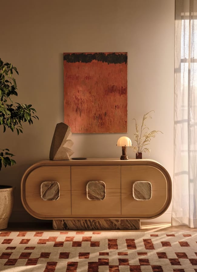 Soho Home Raya Rug, Rust in living space with artwork, plant and sideboard