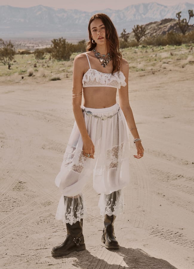 model wearing white lace bloomer set and black boots in the desert