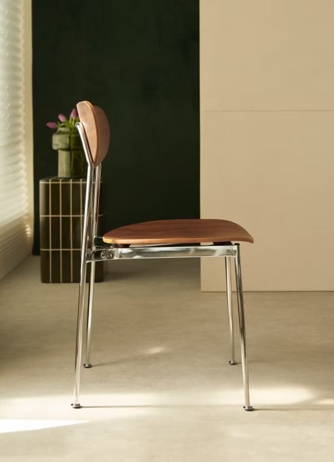 Tikamoon Lilo Chair in walnut and chrome-plated metal in room with black curtains
