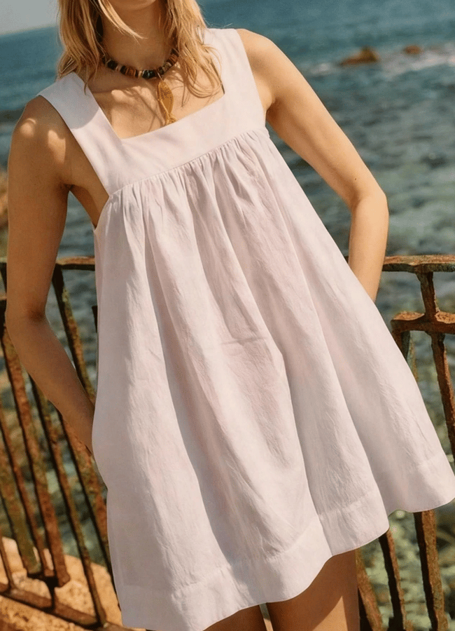 close up of model wearing white sailor sundress on a balcony