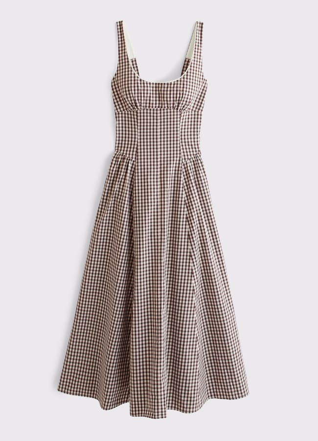 Sleeveless midi dress with a fitted bodice and flared skirt, featuring a brown and white gingham check pattern. The dress has a scoop neckline and wide shoulder straps.