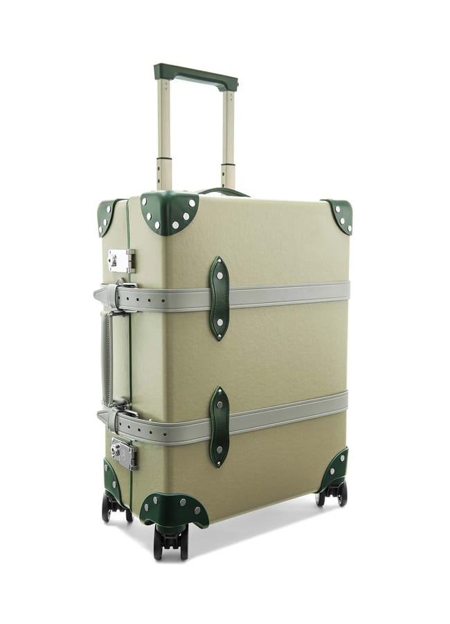 A beige hard-shell suitcase from one of the best suitcase brands, featuring green corner protectors, silver horizontal straps, a retractable handle, side handle, and four black spinner wheels, shown standing upright at an angle.