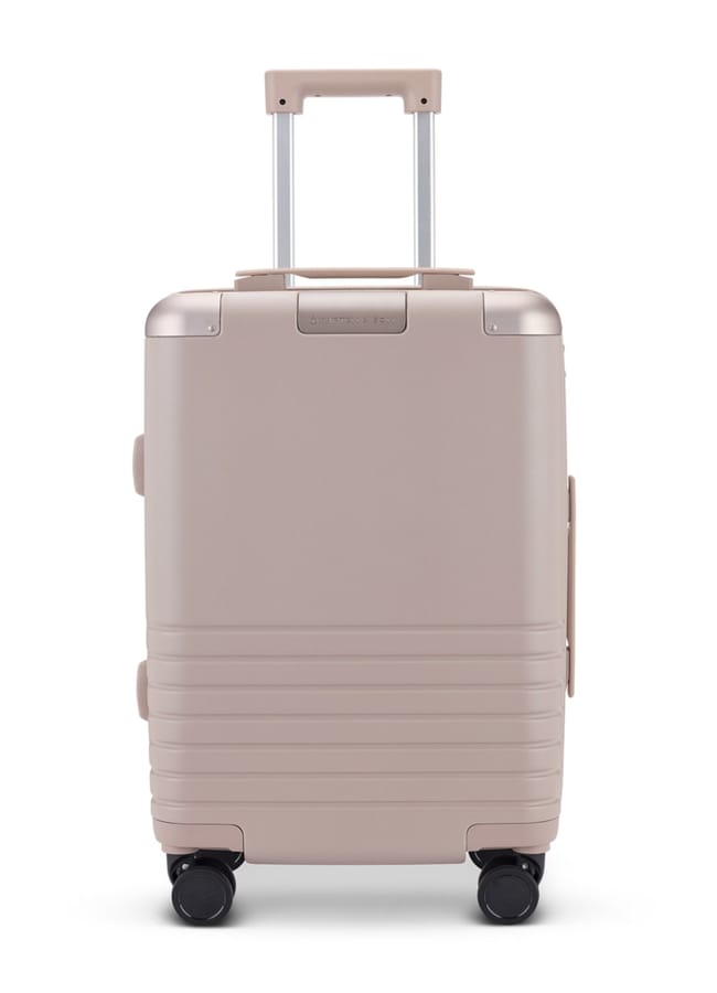 A beige hard-shell cabin suitcase from one of the best suitcase brands, featuring four black wheels, a telescopic handle extended, and horizontal ridges near the bottom. Photographed against a plain white background.