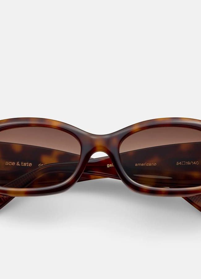 Tortoiseshell rectangular sunglasses with brown lenses, shown from the front on a plain light background. Perfect for deciding what to wear in Ibiza, the frame features wide arms, and product details are visible inside the left lens and on the inner arms.