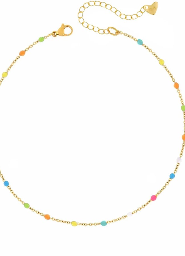 A delicate gold anklet with small, colourful beads spaced evenly along the chain—including pink, blue, green, orange, and yellow beads—and an adjustable clasp with a small heart charm; the perfect finishing touch for what to wear in Ibiza.