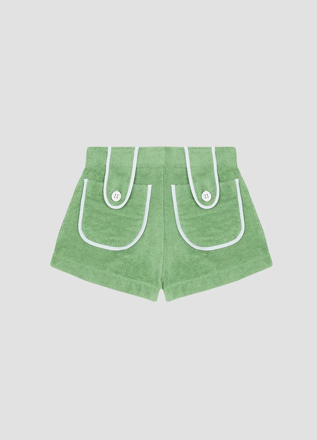 Green towelling shorts with white trim, two front flap pockets with white buttons—an effortless staple for sun-soaked escapes. Perfect for those wondering what to wear in Ibiza, these shorts offer comfort and style, displayed on a plain light grey background.
