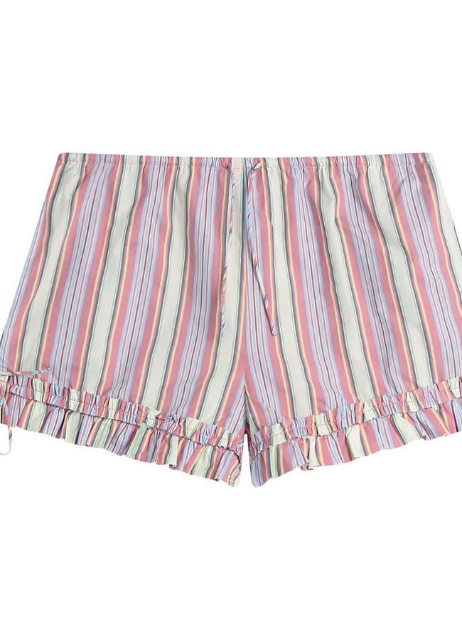 Colourful striped shorts with pink, blue, and white vertical lines, ruffle trim at the hem, and small bows on each side. With a loose fit and an elasticated waistband with a drawstring, these shorts are perfect for what to wear in Ibiza—effortlessly stylish and comfortable for sunny days by the sea.