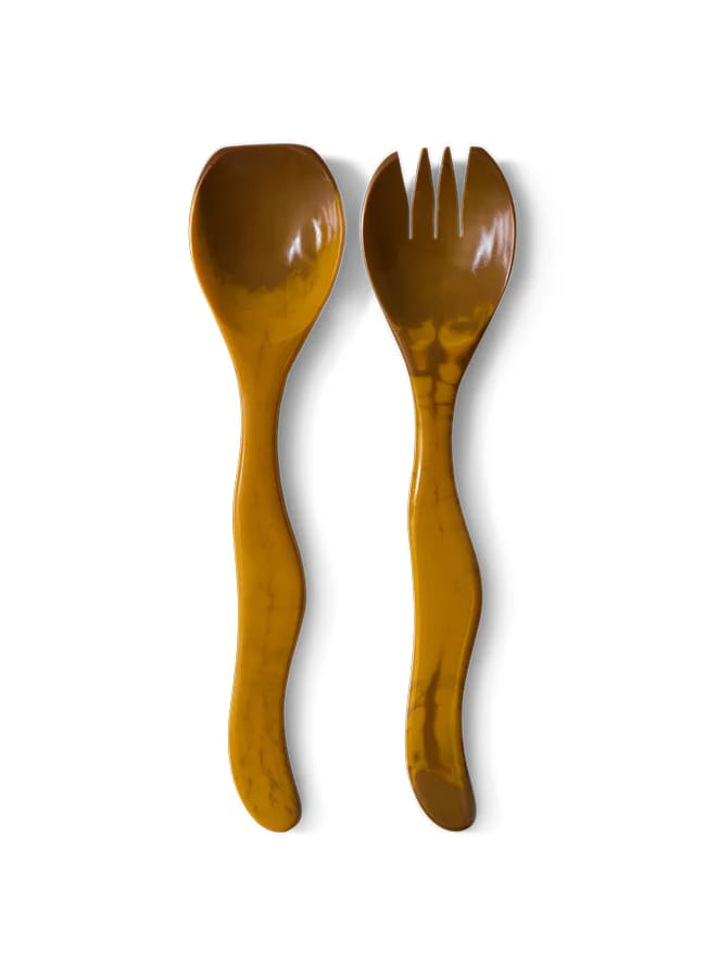 Two wooden utensils with wavy handles—a spoon on the left and a spork with three tines on the right—add rustic charm in warm brown, perfect for salad season, set against a white background.