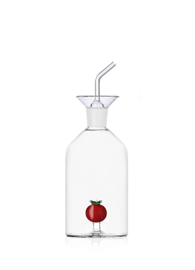 A clear glass bottle with a spout and stopper, featuring a small decorative red tomato inside near the base—perfect for adding style to your table during salad season. Set against a plain white background.