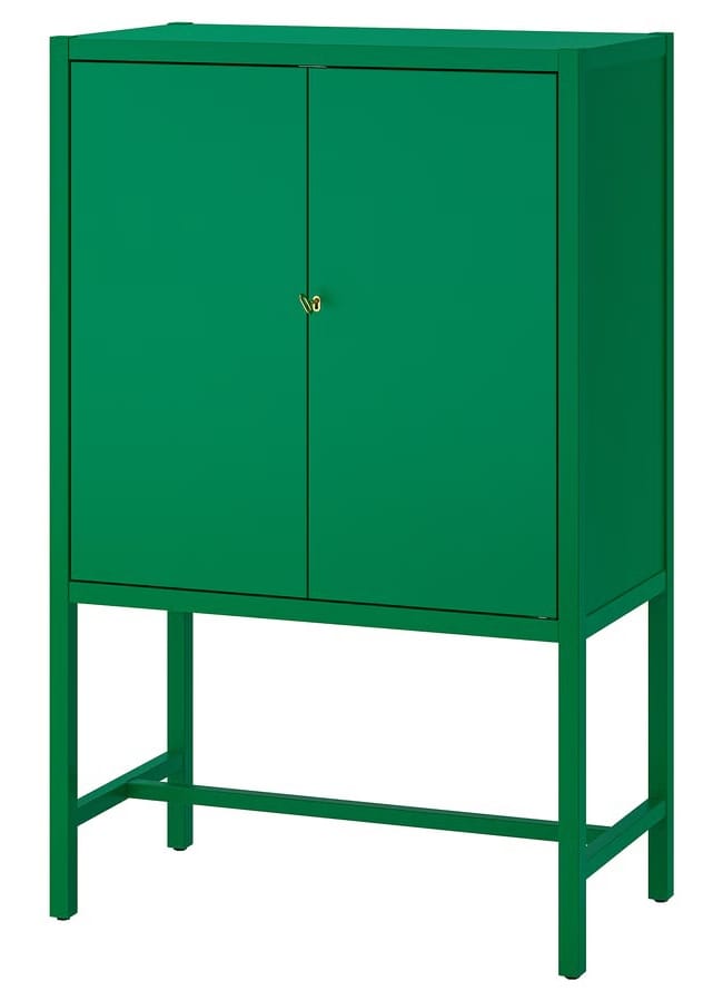 A green metal cupboard with two closed doors and a gold handle, standing on four legs with a rectangular frame and minimalist design, ideal for adding a touch of understated elegance to maximalist hotels.