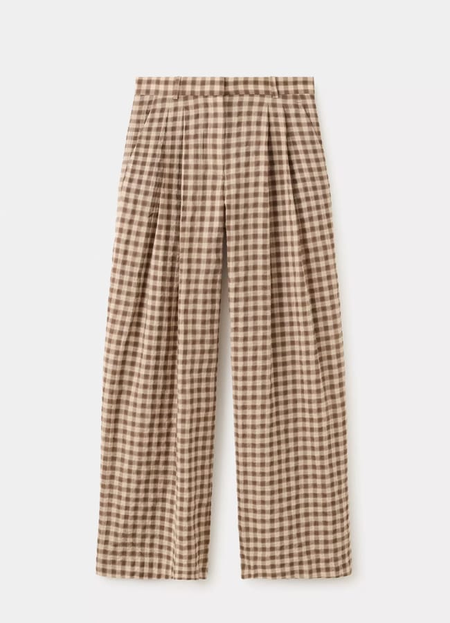 Wide-leg trousers with a brown and beige gingham check pattern, featuring pleats at the waist and a high-rise design, capture the essence of high street fashion, laid flat against a white background.
