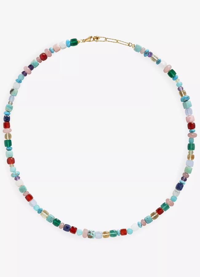 A necklace with small, multicoloured beads in various shapes, strung together in a single strand with a gold clasp—perfect for adding a playful, bohemian touch to your look and an ideal accessory when wondering what to wear in Ibiza.