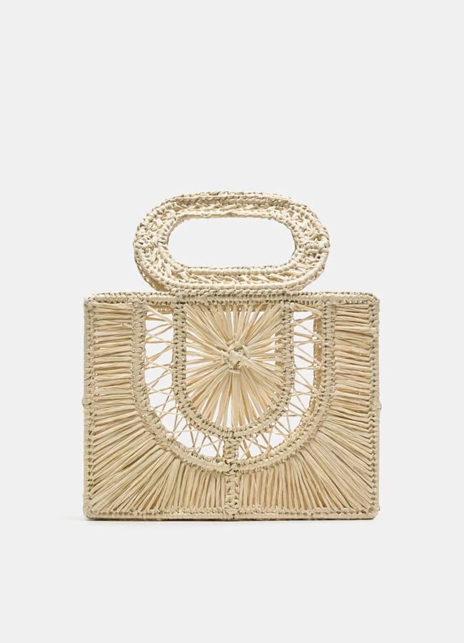 A rectangular woven straw handbag with a geometric pattern and a matching woven handle, displayed against a plain white background—a standout accessory that perfectly complements any high street fashion outfit.